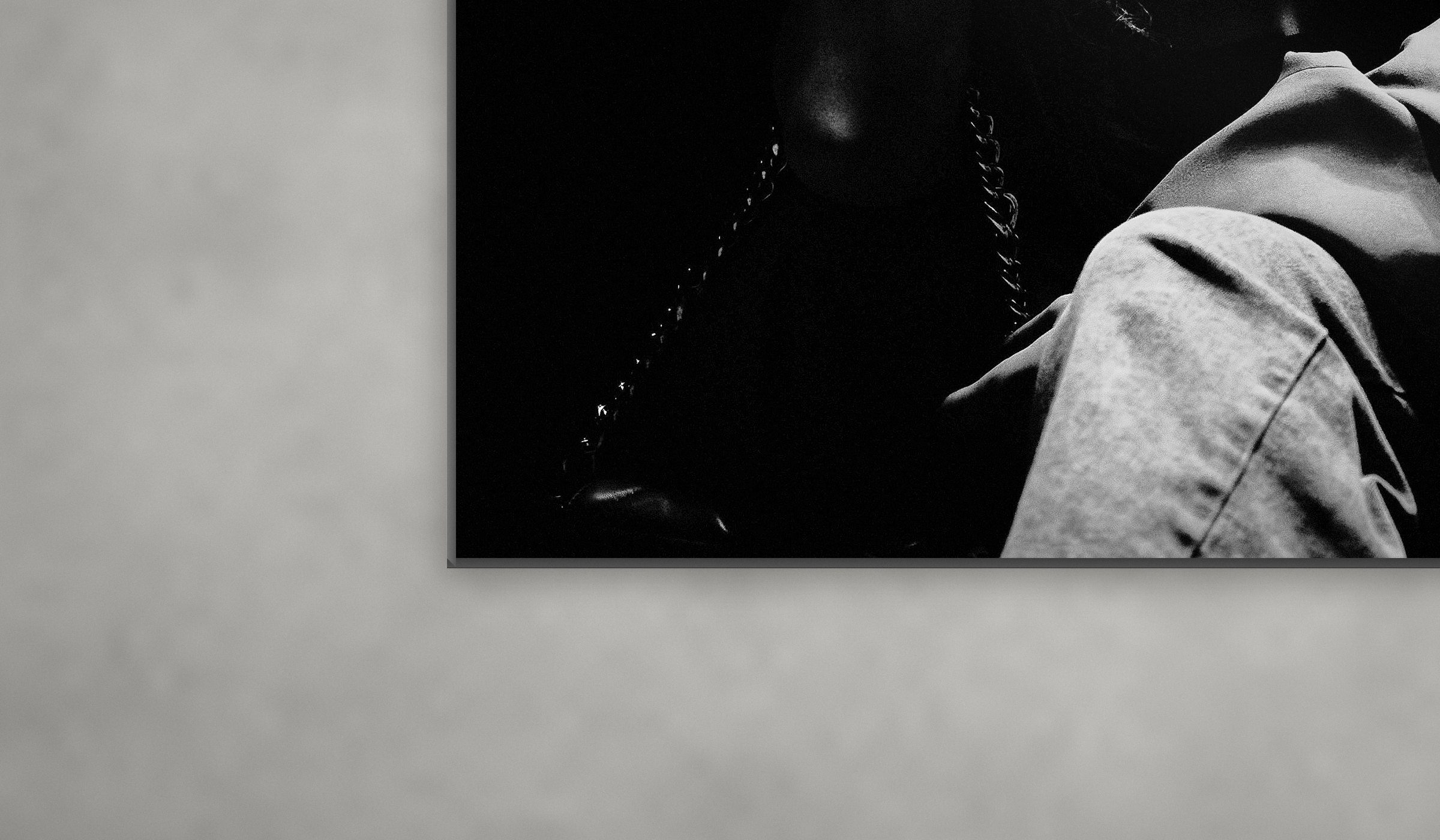 Dettaglio del bordo di un fotoquadro in alluminio, con la sua ombra sulla parete