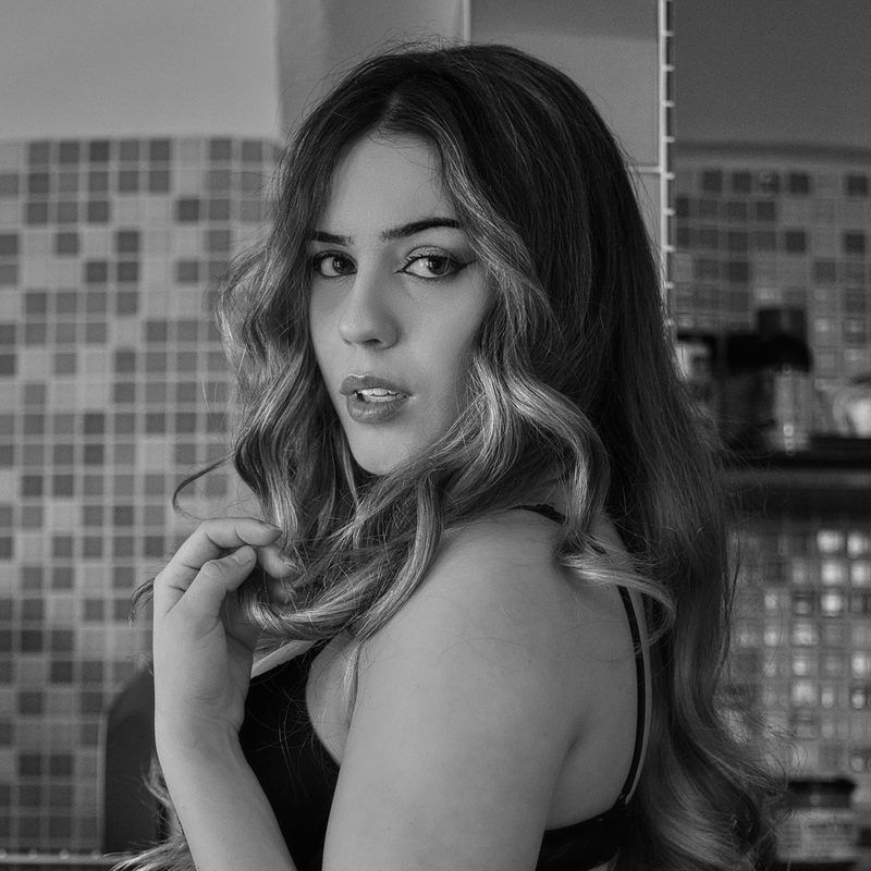 Ritratto in bianco e nero di una donna in un interno, luce di finestra, sguardo rivolto a lato