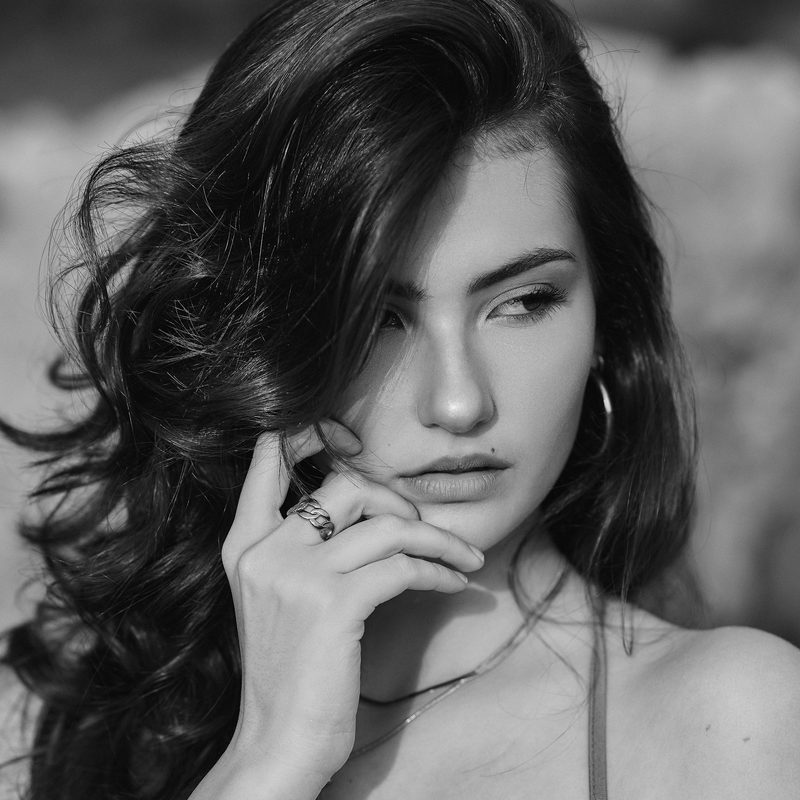 Primo piano in bianco e nero di una donna con la mano davanti alla bocca
