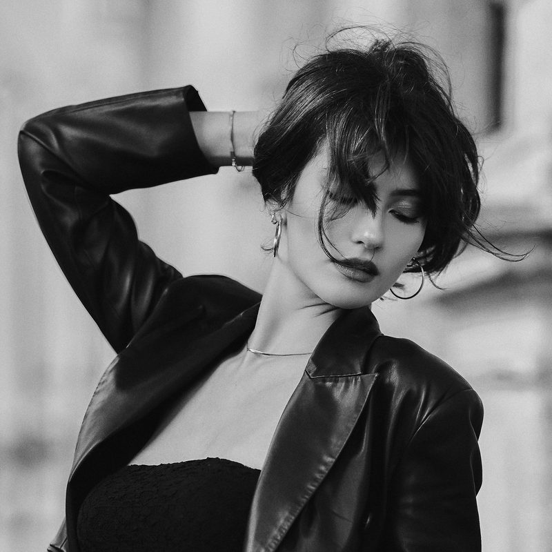 Ritratto in bianco e nero di una donna con i capelli lunghi, la mano al viso