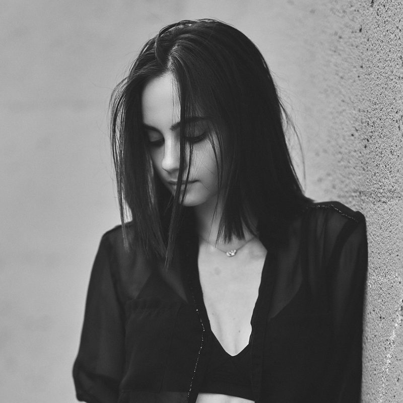 Ritratto in bianco e nero di una donna in giacca scura, la testa appoggiata al braccio