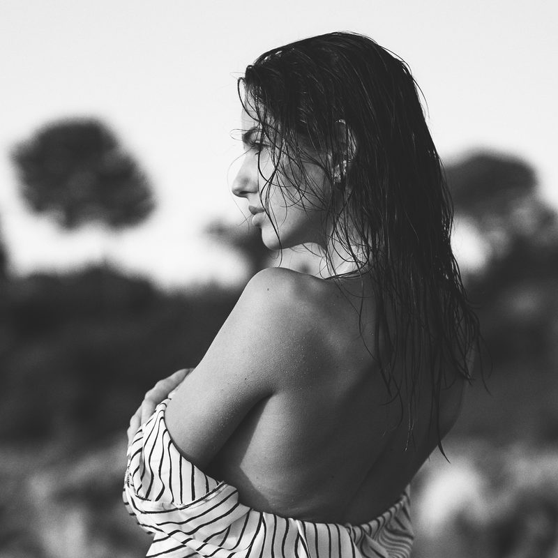 Ritratto in bianco e nero di una donna nell'acqua, la mano tra i capelli bagnati