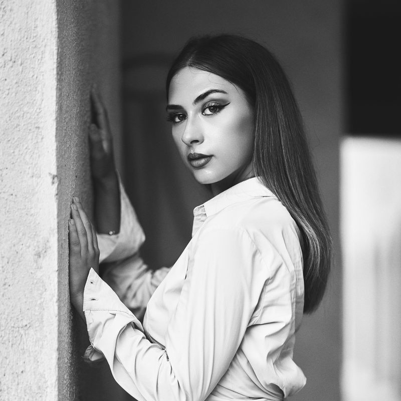 Primo piano in bianco e nero di una donna con lo sguardo diretto, luce di taglio