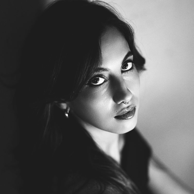 Primo piano in bianco e nero di una donna con i capelli scuri e lo sguardo intenso
