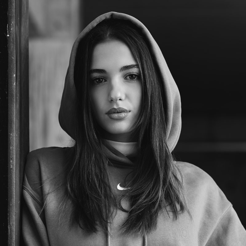 Ritratto in bianco e nero di una donna in penombra, la luce che disegna il viso